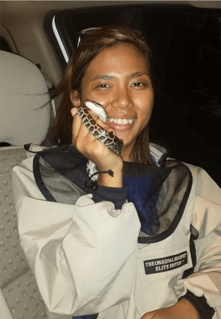 A young woman holding a snake.