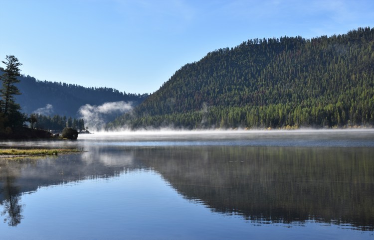 A lake with mist rising from it.